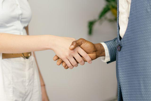 two people shaking hands indoors